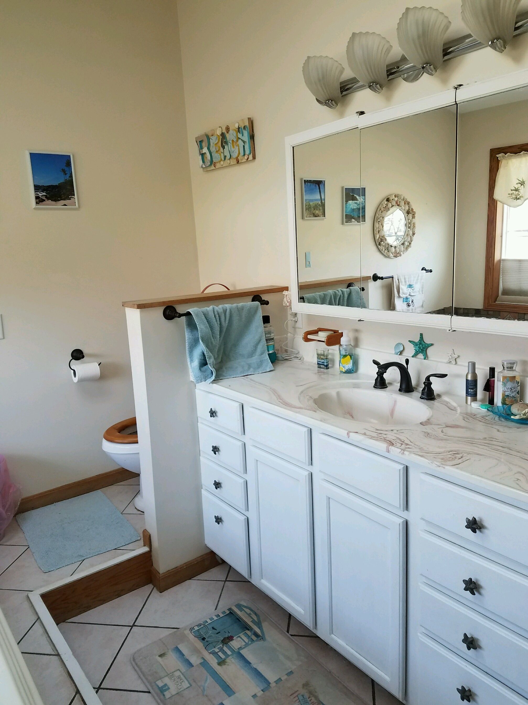 Original white double vanity with large mirror and tile floor.