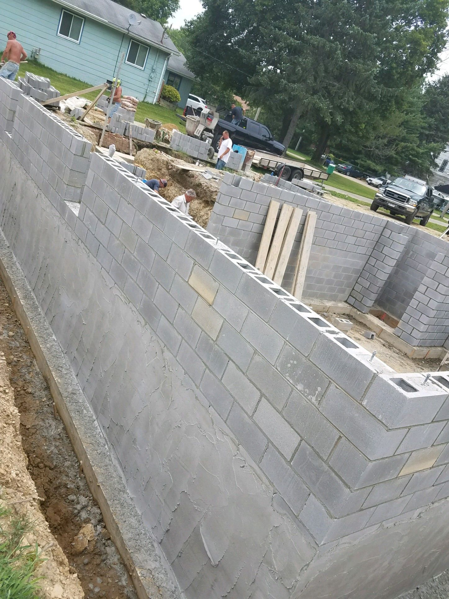 Concrete block foundation walls going up around the excavation.