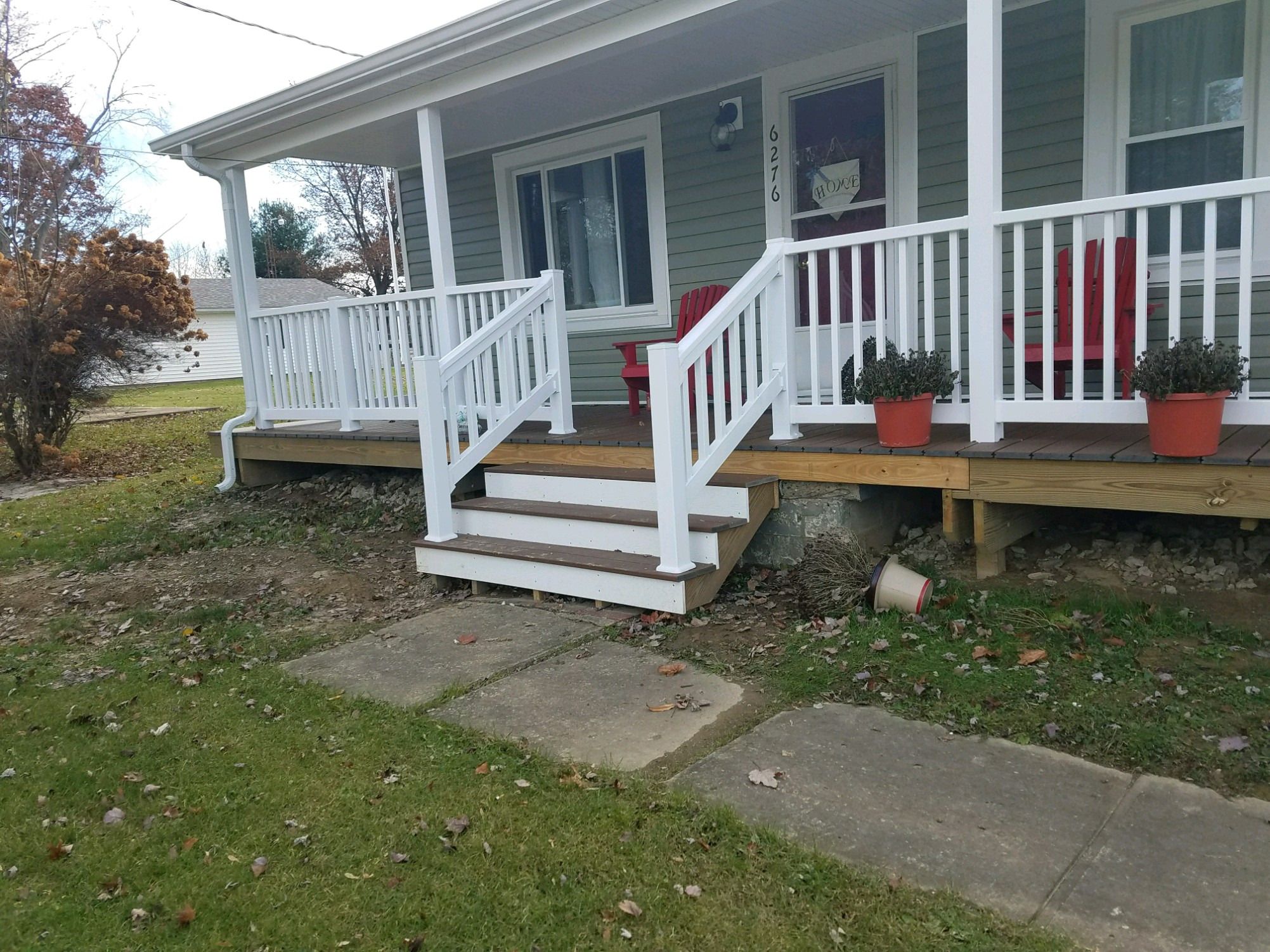 Angled view of the new porch steps with white railings.